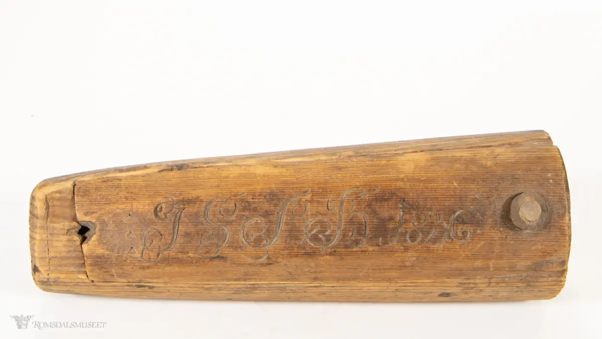 Uthulet stokk med et rom, som smalner av mot enden. Toppen av stokken er skåret av, og skåret til som et dreielokk som dreier om en tretapp. Har en bred, flat base og en uthulet topp, slik at esken kan brukes som en lysestake.