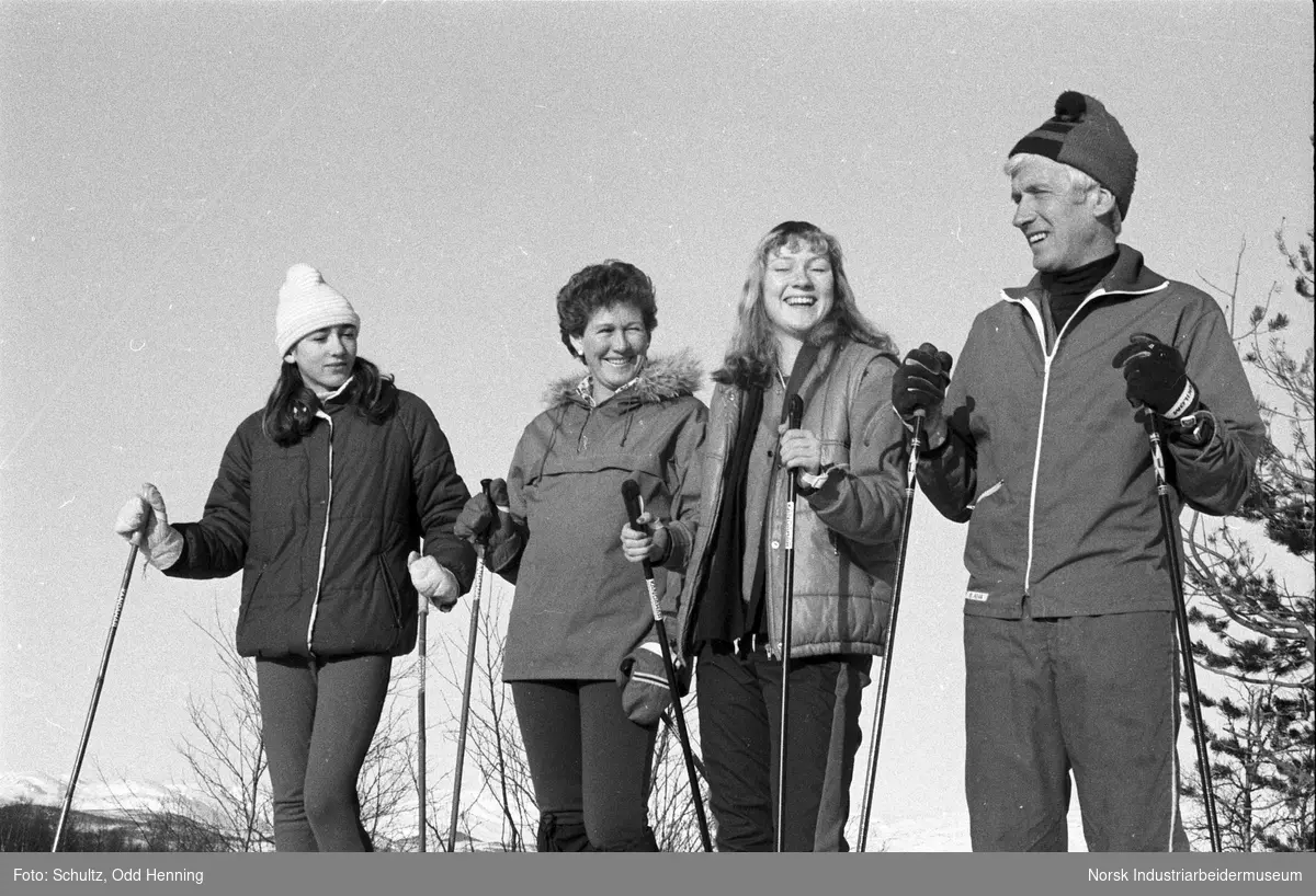 Familie oppstilt for gruppebilde på skitur på fjellet.