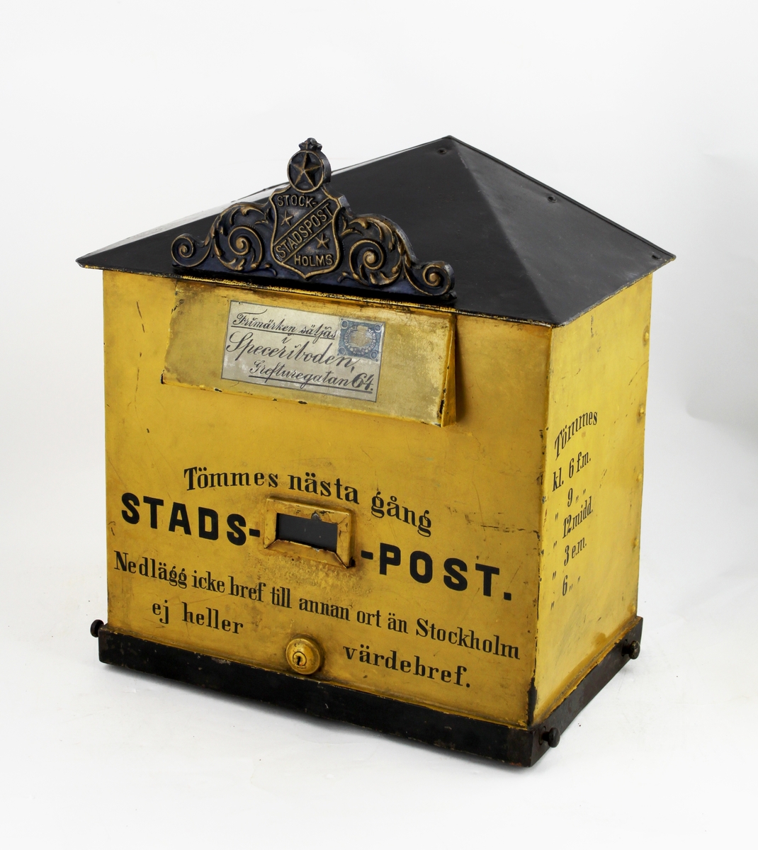 Brevlåda med sluttande, brutet tak. I främre delen av taket ett av Stockholms stadspost emblem. Brevlådans tak och ramen runt brevlådans botten är svart i övrigt är brevlådan gul. På inläggsklaffen ett vitt kuvert med ett av Stadspostens frimärken och texten "Frimärken säljas i Speceriboden Grefturegatan 64".
Där under en liten glasruta avsedd för visning av tömningstider. Brevlådans front har inskription. Brevlådan tömmes från botten med en tömningsväska. Ett lås är centrerat i lådans nederkant. Nyckeln har PM 1642.