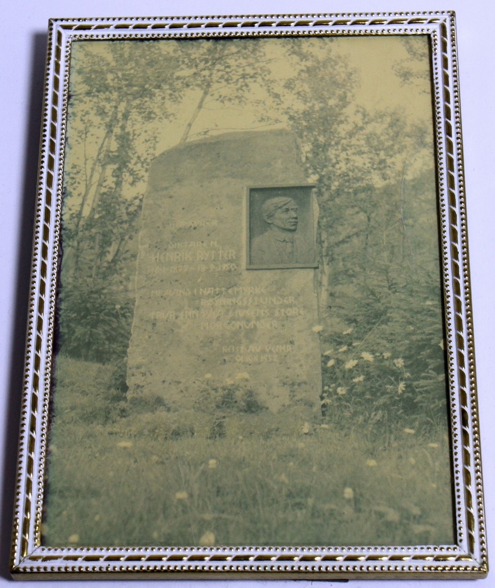 Fotografi av Bautasteinen på "Rytterhaugen" ved den innvigde urneplassen. Fotografiet kjem frå 1962. Det står vidare: "Jonsok 1952 vart bautaen reist av bygdefolket i Ustedalen og på Geilo, og andre vener. Dei siste linene Henrik Rytter skreiv, er hogd inn på bautaen: Og likevel ja, likevel mi ånd i nattemyrke røyningsstunder trur enn på livsens store morgonunder". Vedlagt fotografiet følgjer ei informasjonstekst. Både foto og tekst er i glas og ramme. Biletet av bautaen har måla 12,2 x 17,2 cm, medan teksten har måla 18 x 18 cm.