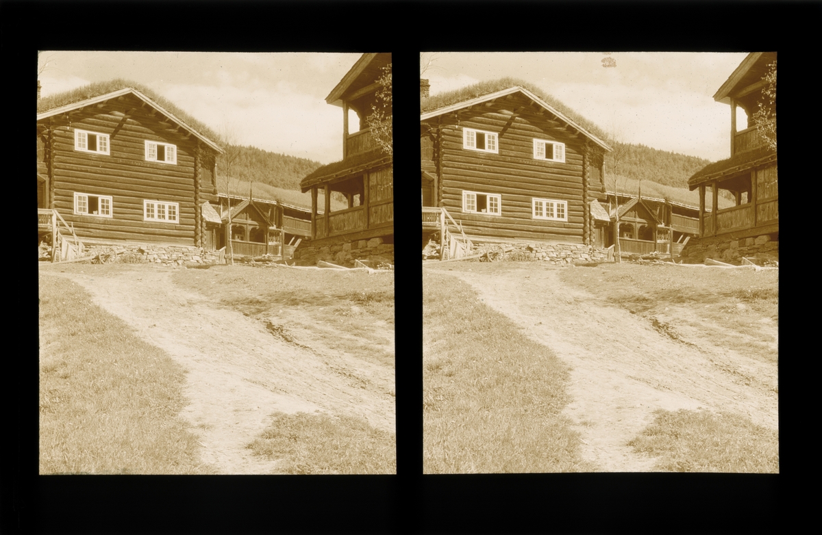 Laftede trebygninger ved Bjølstad gård, fotografert fra veien. Tilhører Arkitekt Hans Grendahls samling av stereobilder.