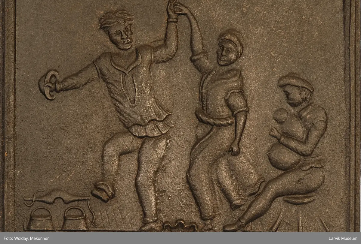 dansende bønder til høyre spillemann med sekkepipe sittende i profil mot venstre på lav krakk til venstre vassele og to trebøtter.