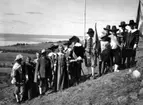 Ett sällskap män och kvinnor i historiska dräkter står på en slänt på Grännaberget. De agerar greve Per Brahe d.y. med följe i samband med hembygdsfest.