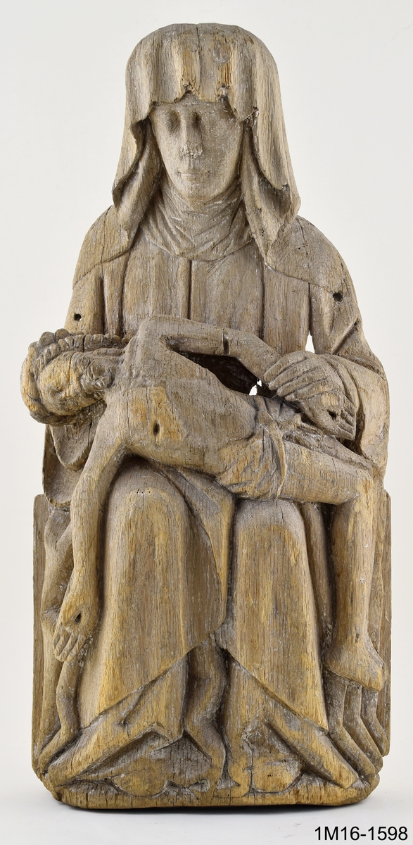 Skulptur, Marie klagan (Pieta). Maria sitter med sin döde son i knät. Huvudet täckt av en slöja som faller ned över axlarna, är böjt åt höger. Vänster hand håller den dödes vänstra arm. Kristi törnekrönta huvud är nedsjunkt mot Marias högra arm. Kristi högra arm hänger rakt ned vid Marias högra knä. Underbenen hänger vertikalt mot marken. Kristus bär ländkläde och har korsfästelsens sårmärken återgivna. Marias mantel är rikt draperad över armar och ben. Hål i huvudet för relikgömma. Spår av kreditering och brun färg. Vertikala sprickor och hål. Urholkad på baksidan. Tidigare placerad i Edåsa kyrka.