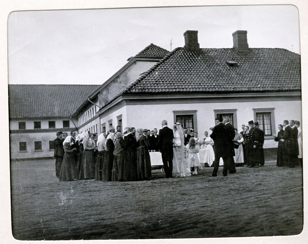 Bryllupsfeiring på Bogstad gård. Brudeparet Nini og Westye Egeberg, med ryggen til, møter de ansatte på gårdsplassen. Fotografert 17.09.1904.