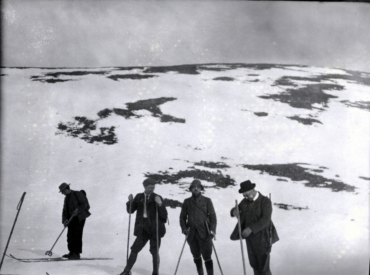 Fire skigåere raster underveis i Sikkilsdalen. Fotografert påsken 1905.