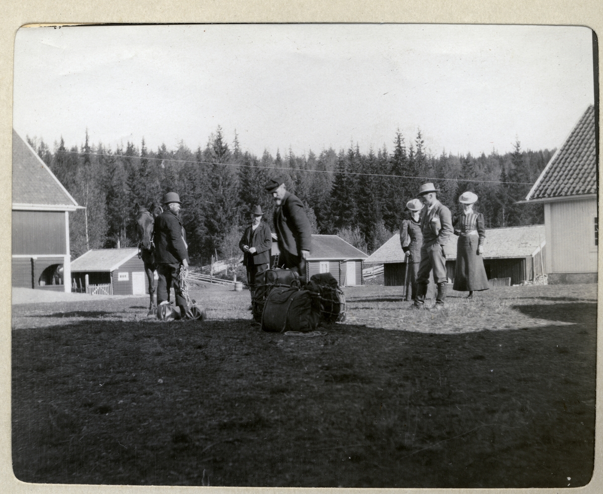 Fire menn og to kvinner, trolig på vei til jakt, på Egeberg-familiens eiendom ved Malungen, Stange i Hedmark. Hest og fullpakkete ryggsekker er klar. Fotografert 1906.