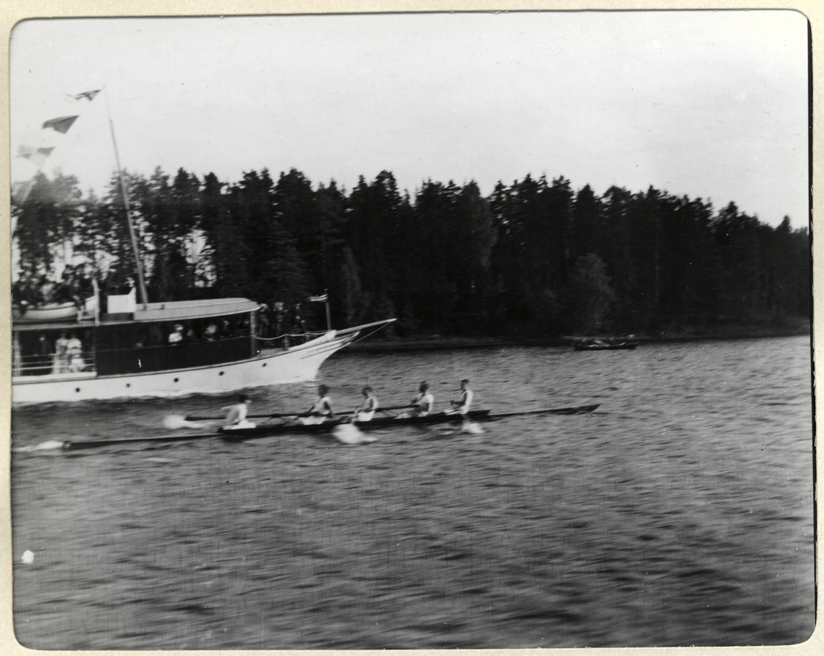 Robåt med fire roere og styrmann passerer en lystbåt under en roregatta i Holtekilen i Oslofjorden. Fotografert i august 1907.