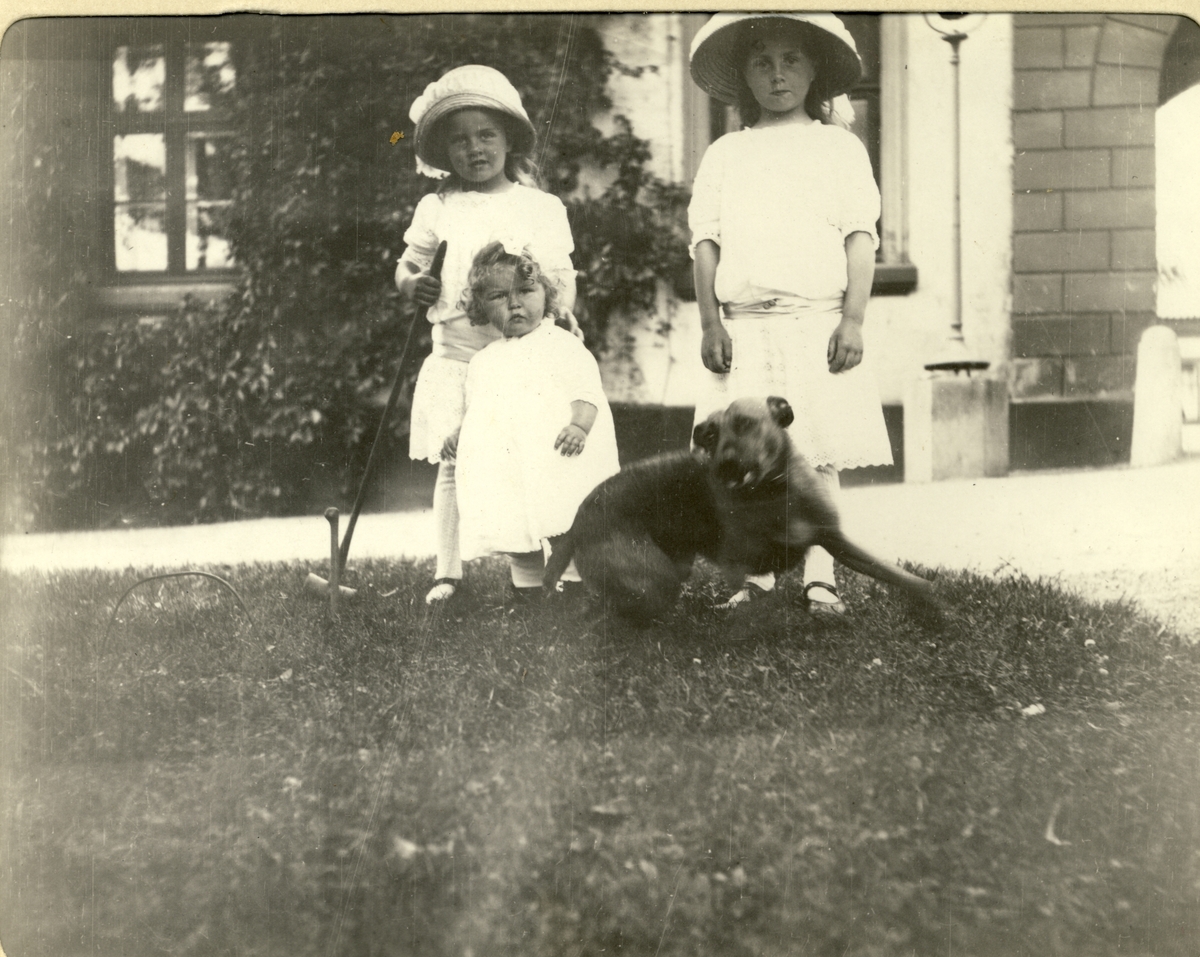 Søstrene Karen, Lucy, Mimi Egeberg og hunden "Bob"  i parken på Bogstad gård. Fotografert 1912.