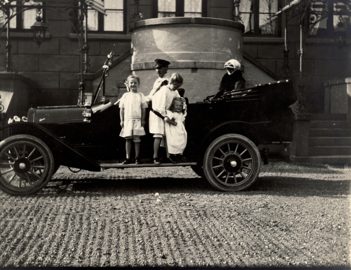 Familien Egeberg klar til avreise fra hovedinngangen til Bogstad gård. Fra venstre Lucy, Mimi, Karen og Nini Egeberg. Bilen av merket Overland kjøres antagelig av sjåfør Kristian Skuggen. Fotografert 1913.