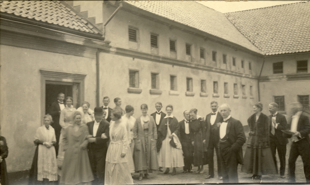 Storfamilien Meyer samlet på gårdsplassen til Bogstad gård i forbindelse med en familiemiddag. I midten Nini Egeberg i hvit kjole og mørk cape. Fotografert juni 1917.