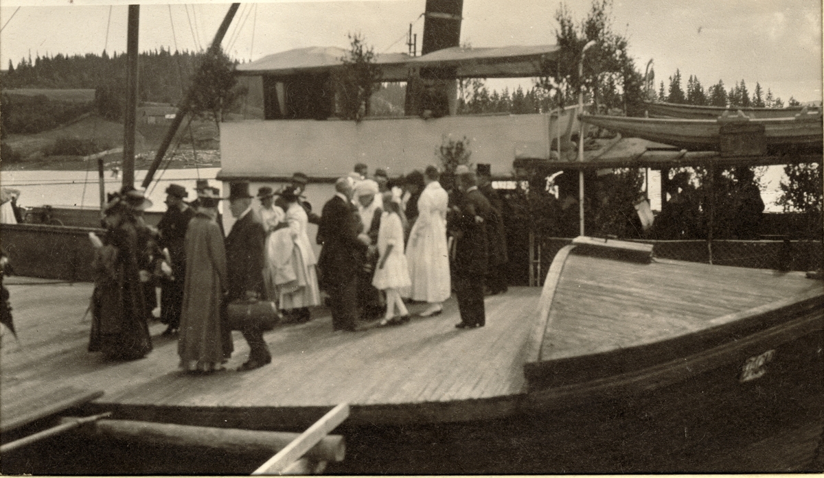 Festklædte gjester ankommer til feiring av Lilla og Fredrik Giertsens sølvbryllup med dampskipet D/S Strømmen, som gikk på Øyeren. Fotografert 1918.