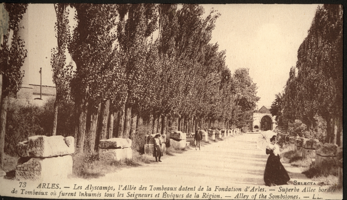 Allée des Alyscamps i Arles, med gravstøtter og -stener langs alléen. Alyscamps er en stor romersk nekropolis og ble skrevet inn på UNESCOs verdensarvliste i 1981. En kvinne går ytterst til høyre. Antagelig et postkort kjøpt under en reise i 1922.