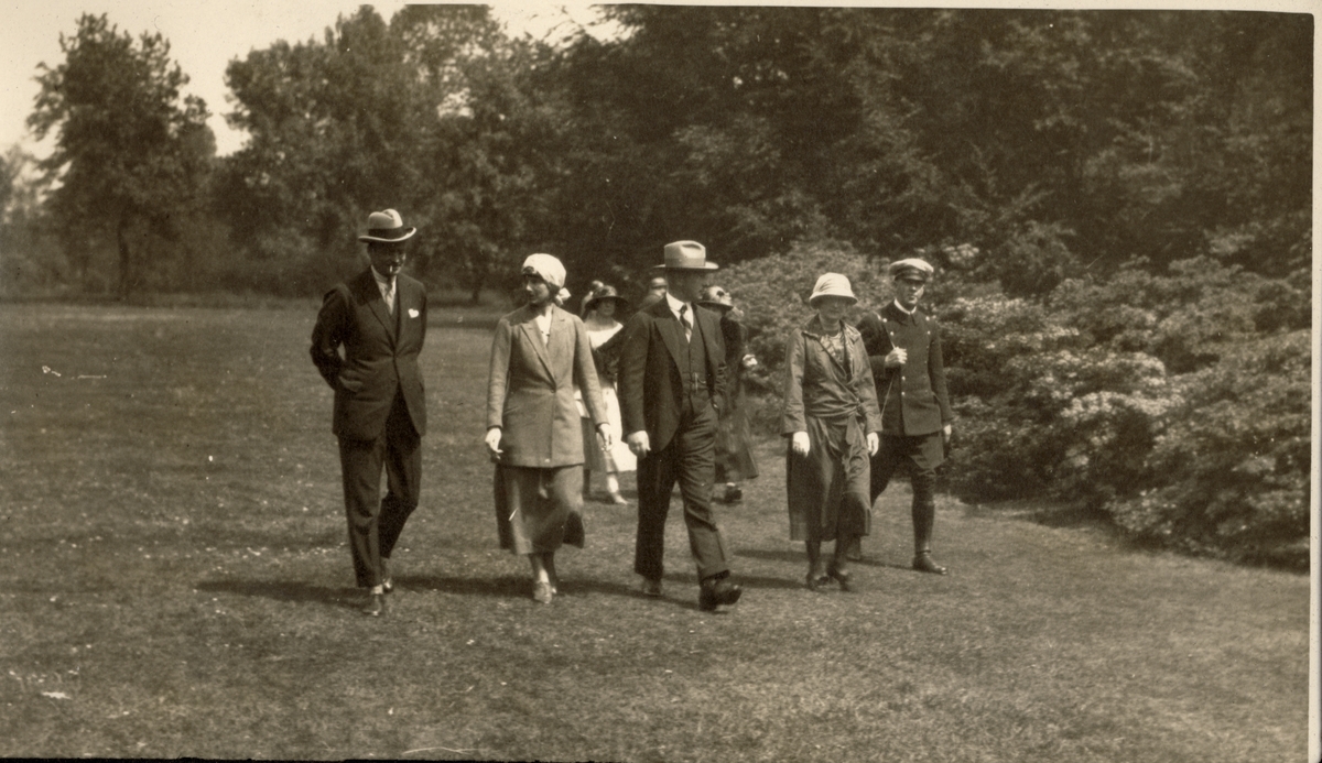 En gruppe på fem personer spaserer i Kew Gardens utenfor London. Fra venstre Nils O.Y. Fearnley, Cecilie(?), Westye P. Egeberg, Benedicte Fearnley og sjåføren Øivind. Fotografert 1923. 
