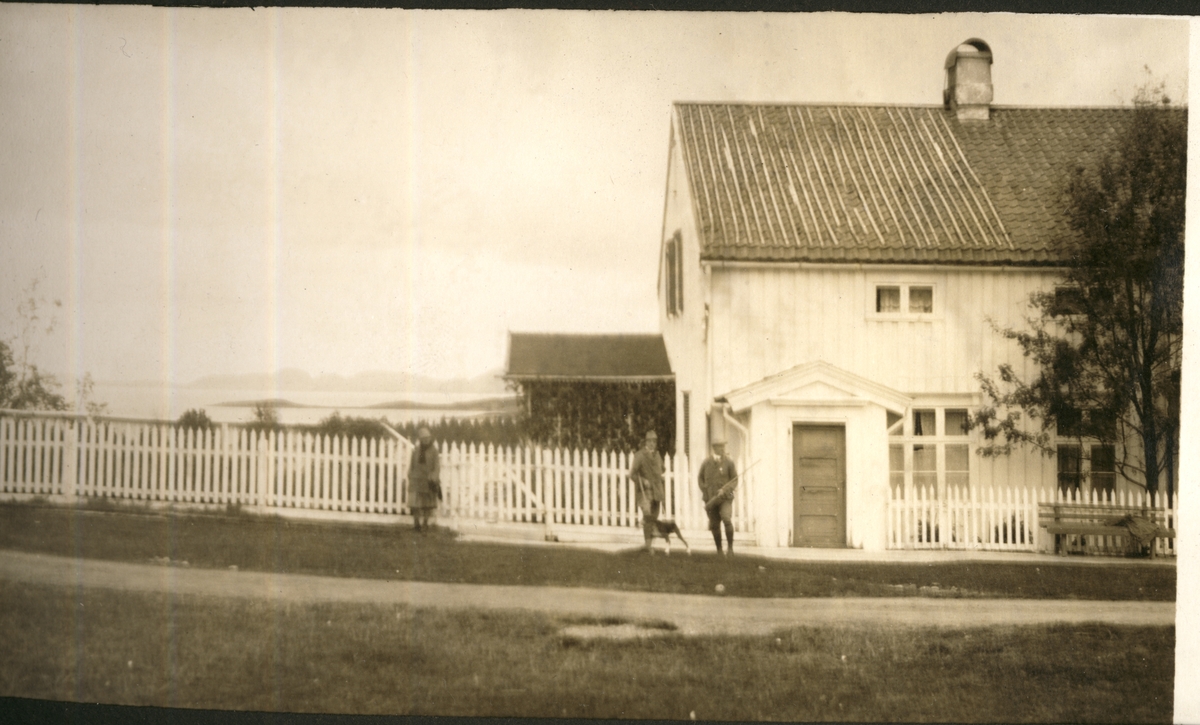 Mo Gård i Namdalen, tilhørende Firmaet Albert Collett, ligger ytterst mot havet, Foran skimtes en kvinne og to menn. Fotografert september 1923 i forbindelse med elgjakten.