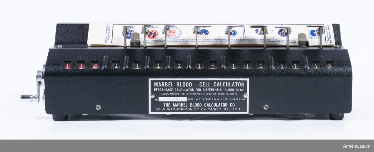 Svart räknekammare med tillhörande bruksanvisning och garanti-kort på engelska.

Skylt på föremålets framsida med tillverkaruppgifter, modellspecifikation och serienummer: 
"Marbel blood - cell calculator
percentage calculator for differential blood films
adding machine for erythrocytes, leucocytes, blood platelets
NO 276 model VI-T, patented june 6, 1922 others pend.
The Marbel Blood Calculator CO.
30 W Washington St. Chicago 2, Ill, Chicago"