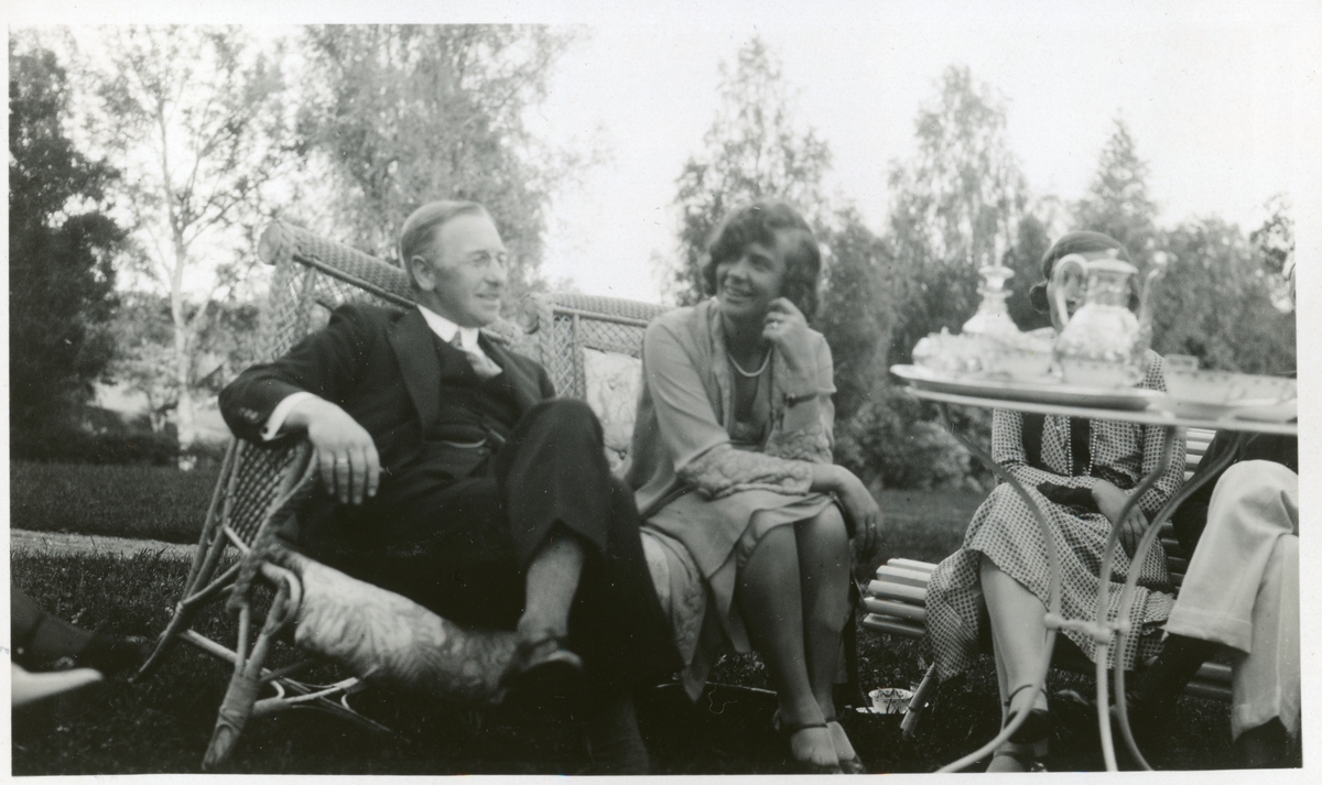 Westye P. Egeberg og Hatti Blom ved kaffebordet i hagen til Bjerke gård i Enebakk, Akershus. Fotografert 1930.