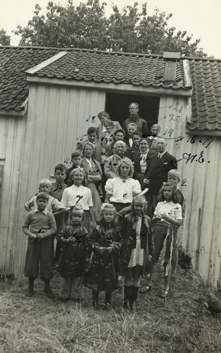 Nini og Westye Egeberg med familie og andre samlet på låvebroen, etter at barnebarn og lekekamerater har hatt forestilling på låven. Ukjent sted.