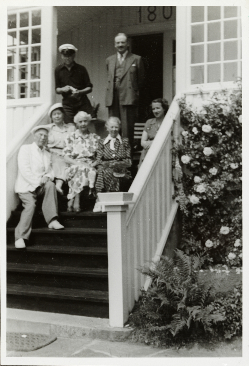 Leif Høegh, Barthold Butenschøn, Lilly Egeberg, Mabel Butenschøn, Dagny Plathe, fru Lie og Westye Egeberg på trappen til huset i Dannevigen i Homborsund. Fotografert 1944.