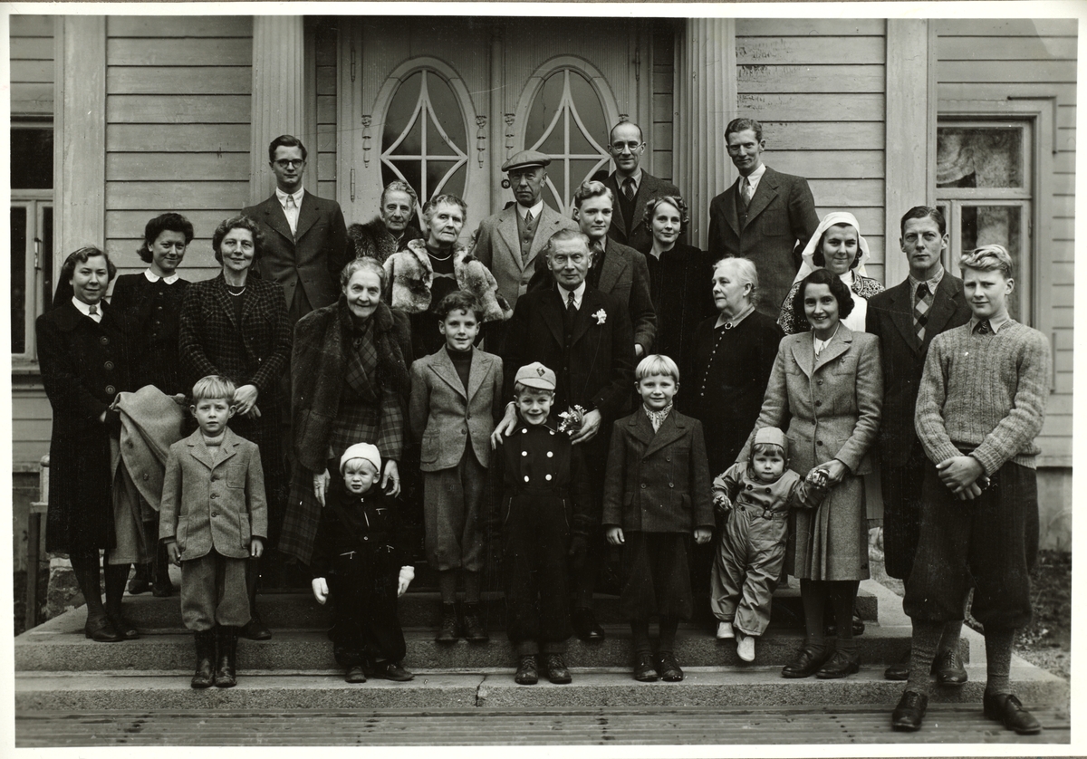 Gruppebilde tatt i forbindelsen med feiring av Carl Løvenskiolds 70-års dag hos Jørgen Mathiesen på Eidsvoll Verk. I tillegg til familiene Løvenskiold og Mathiesen deltok Nini og Westye Egeberg. Til høyre med hvitt tørkle står Egeberg-familiens Dada, Gunvor Andersen. Fotografert 3. november 1944.
