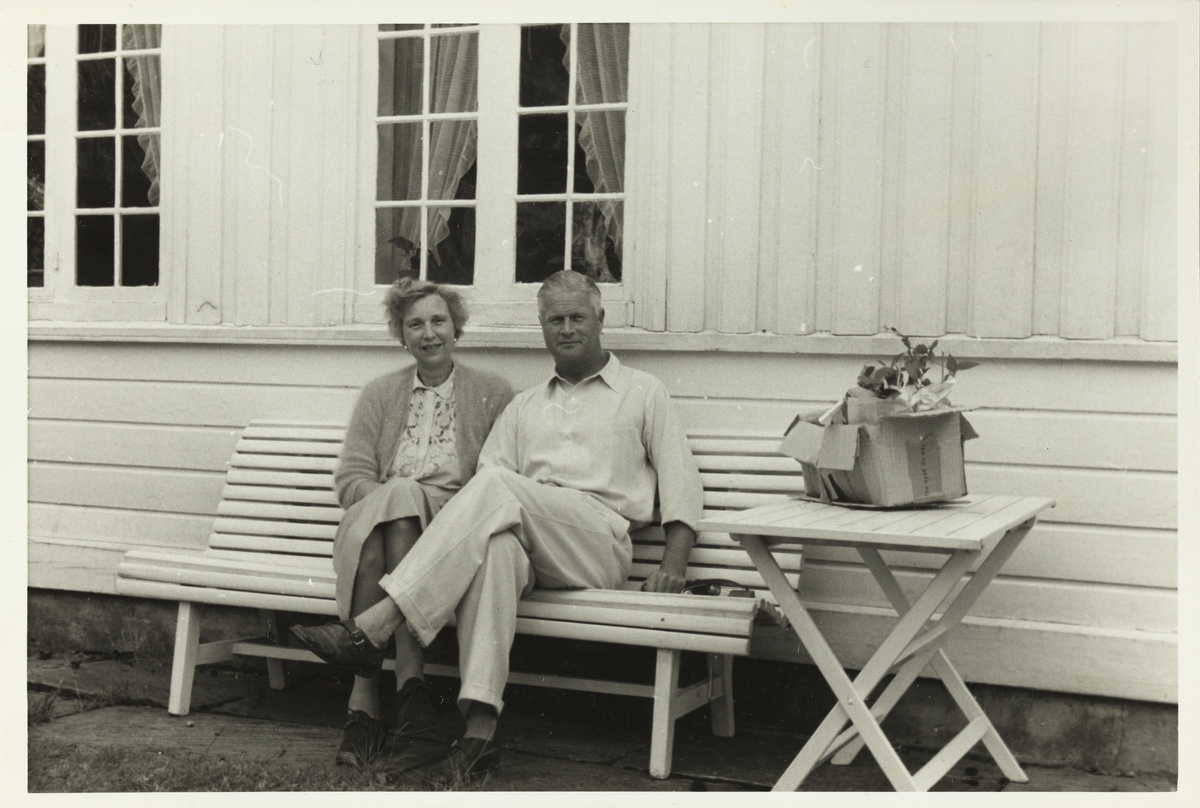 Evelyn og Herman S. Løvenskiold på hagebenk på landstedet Dannevigen i Homborsund. Fotografert 1953.
