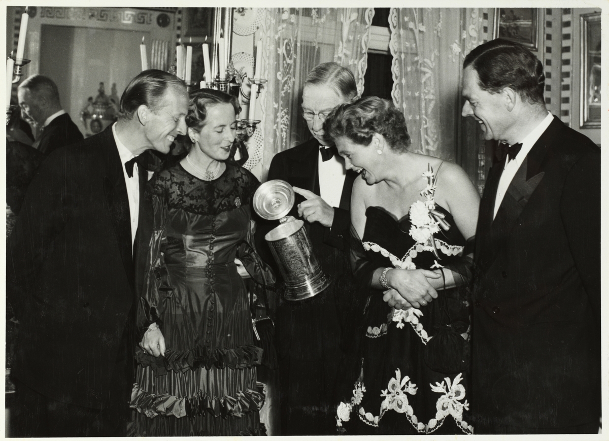 Fest for Arkitektforeningen på Bogstad gård i september 1953. Fra venstre arkitekt G. Dick Advocaat, Mimi Grieg Halvorsen, Westye Parr Egeberg, med det Leuch-ske sølvkrus fra 1640, ukjent kvinne og arkitekt Esben Poulsson.