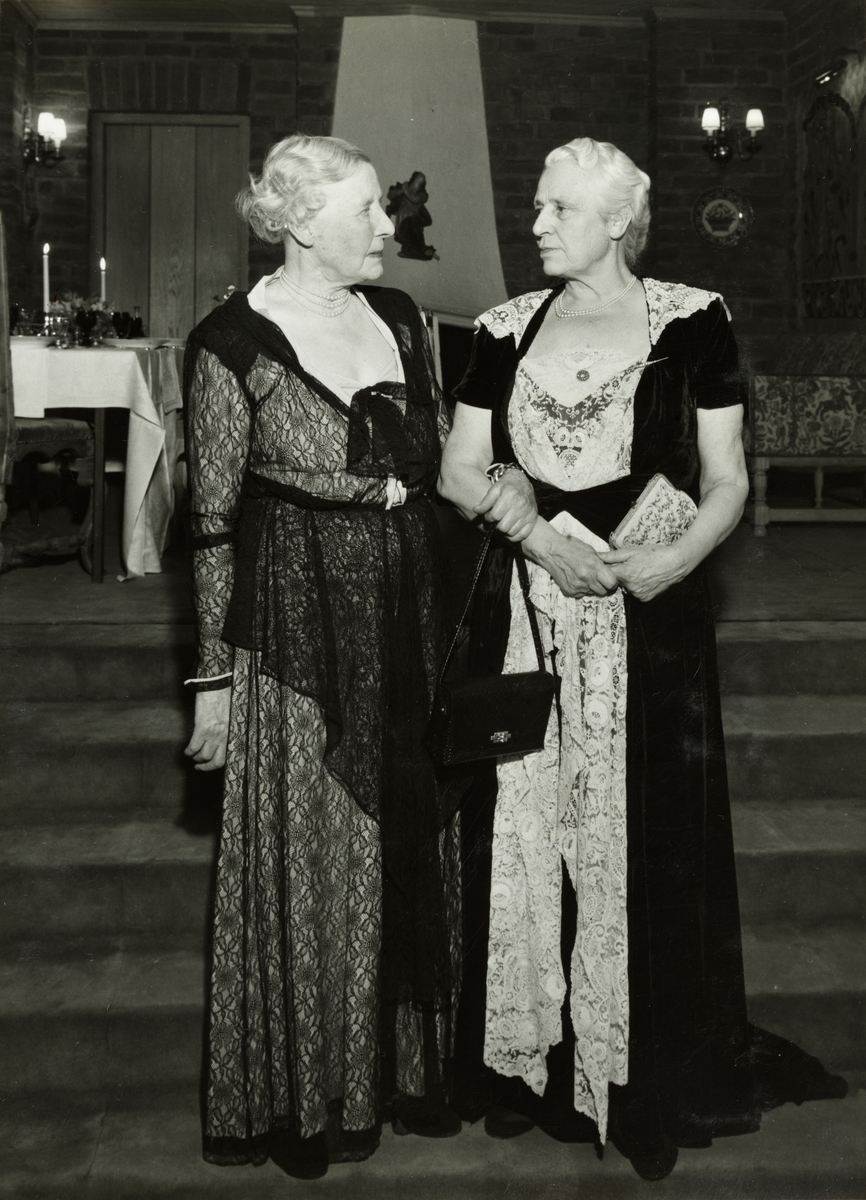 Fra 100-års festen for godseier Carl Wedel-Jarlsberg, Atlungstad gård, 20 februar 1954. To av hans døtre, Nini Stang og Harriet Schultz, i selskapskjoler.