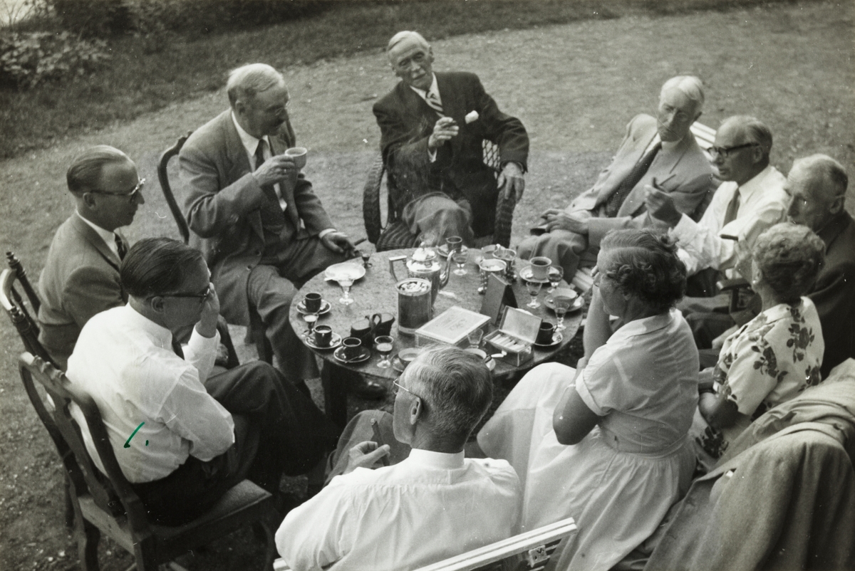 Familie og venner fra skiklubben Fram feirer Anders Beers 80-års fødselsdag i hagen på sommerstedet på Larkollen. Fra venstre Carl Johan Heiberg, Nicolai Beer, Barthold A Butenschøn, Viktor Plahte,  Søren Chr. Sommerfelt, Arne Meidell, Carl Rustad, Lizzie Beer, Ingeborg Heiberg og Thorry Kiær. Fotografert juli 1955.