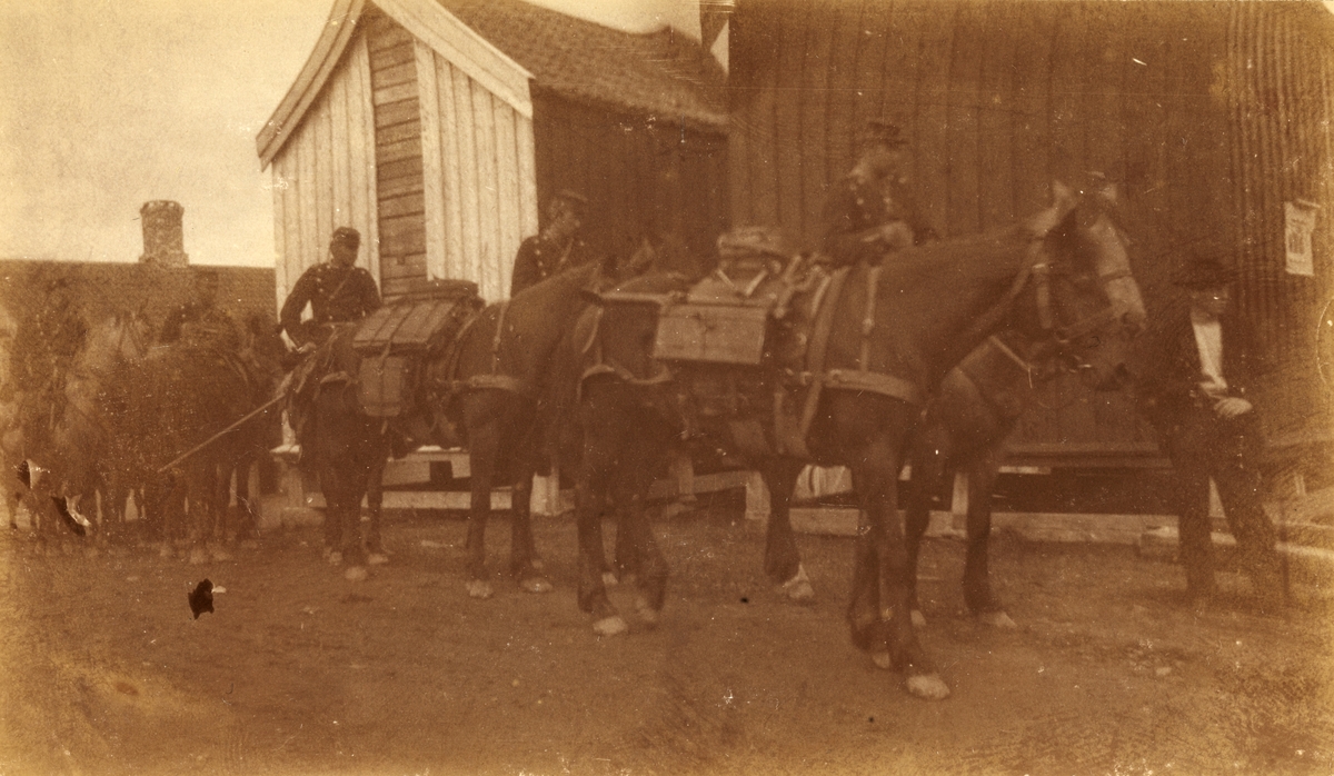 Kavaleri med oppakning på vei gjennom bygate, antagelig i Levanger i forbindelse med avslutning av feltøvelse i 1901.