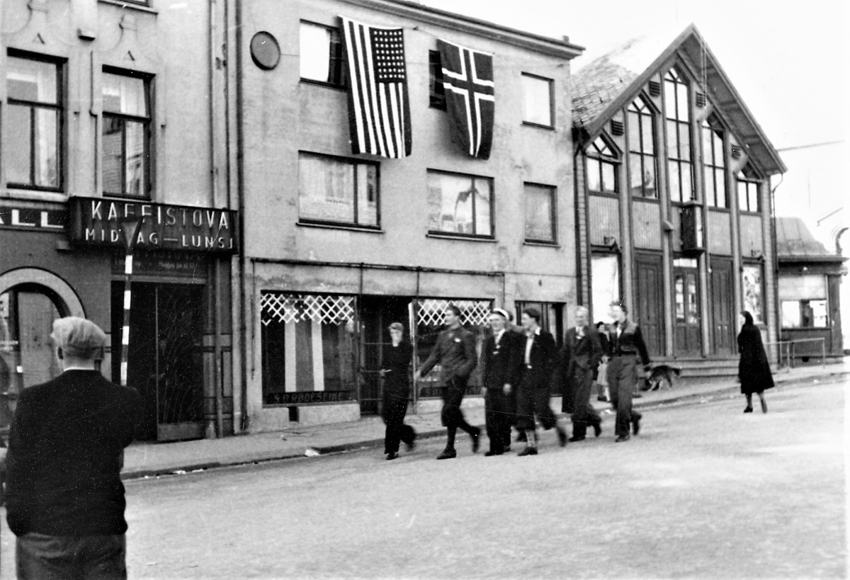 Feiring av freden 1945. En liten gruppe russ vandrer i bygaten.  "Kaffistova" til venstre i bildet.