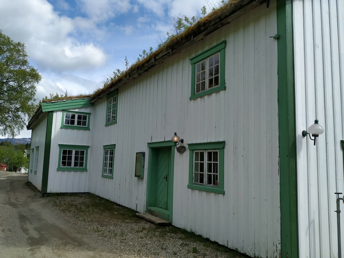 Laftet hus i to etasjer. Opprinnelig bygget som kornmagasin nede ved fjorden i forbindelse med nødsårene i 1812-1814. Flyttet opp som ett tilbygg til eksiterende våningshus i 1870. Avdelt da i etasjer og rom, bordkledd utvendig og panelt innvendig.
