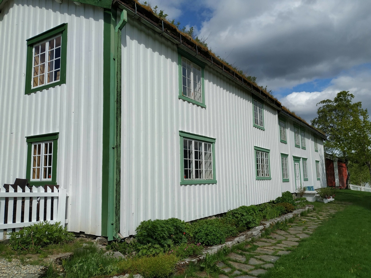 Laftet hus i to etasjer. Opprinnelig bygget som kornmagasin nede ved fjorden i forbindelse med nødsårene i 1812-1814. Flyttet opp som ett tilbygg til eksiterende våningshus i 1870. Avdelt da i etasjer og rom, bordkledd utvendig og panelt innvendig.