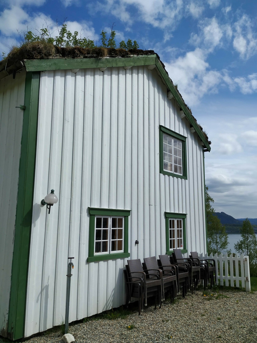 Laftet hus i to etasjer. Opprinnelig bygget som kornmagasin nede ved fjorden i forbindelse med nødsårene i 1812-1814. Flyttet opp som ett tilbygg til eksiterende våningshus i 1870. Avdelt da i etasjer og rom, bordkledd utvendig og panelt innvendig.