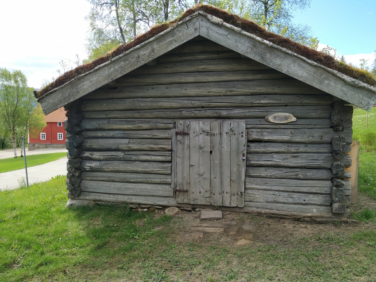 Laft rundtømmer uten meddrag. Steinmur og torvtak.