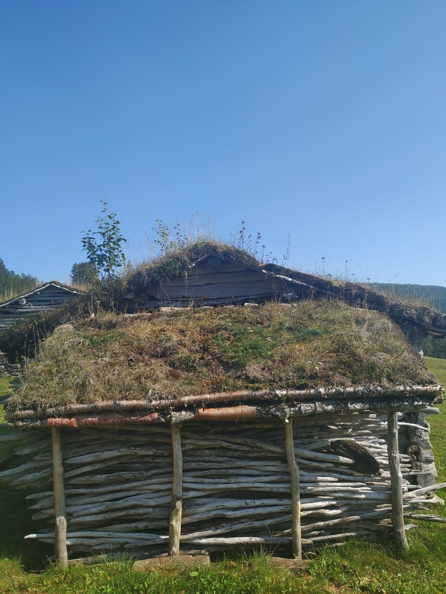 Masstue. Steinmur på grunnen, to laftet av rund tømmer med reisverk mellom byggene. Takåser, tro, næver og torv. Første bygning på Bredek, da brukt både til bolig og fjøs. 