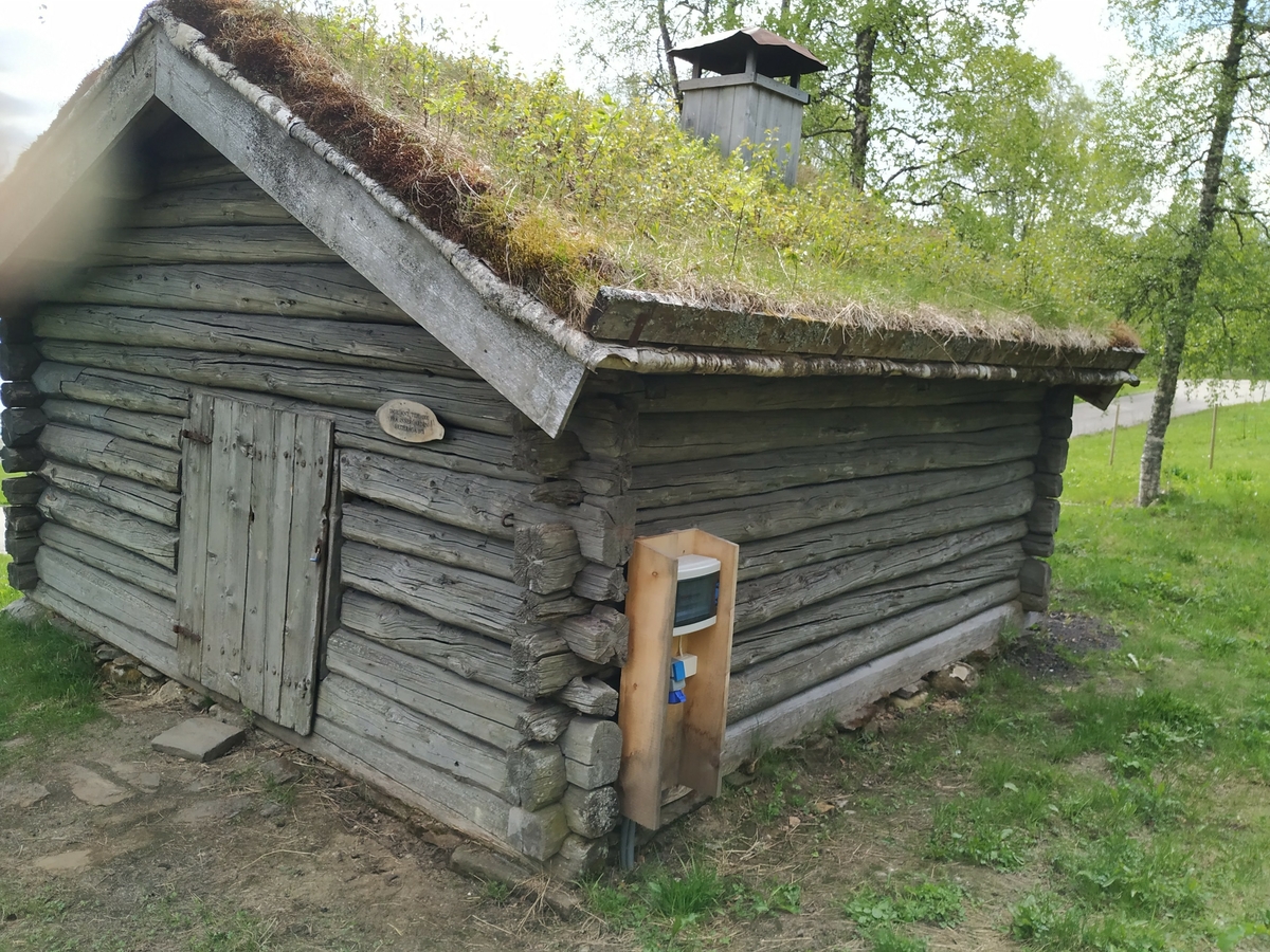 Laft rundtømmer uten meddrag. Steinmur og torvtak.