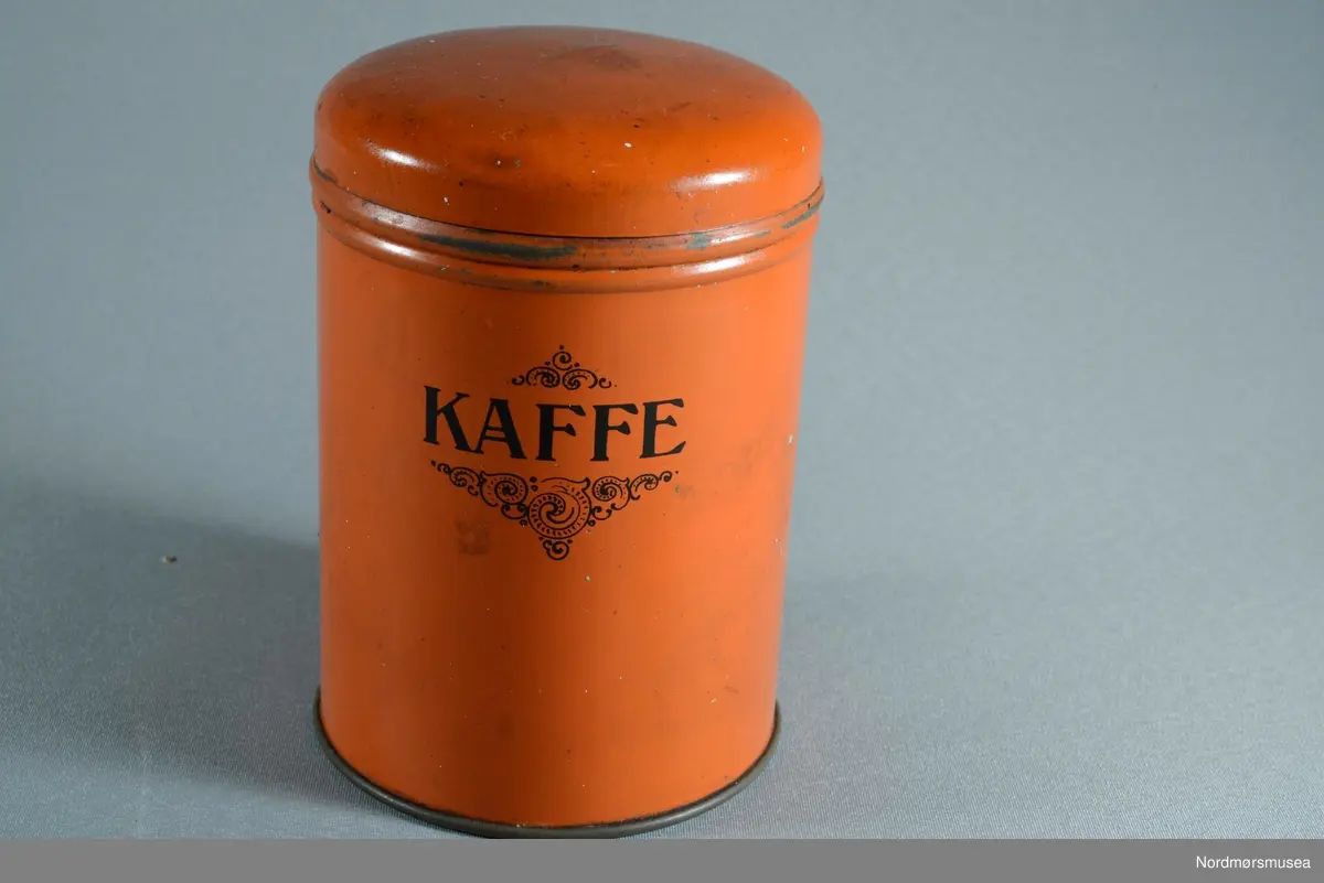 3 bokser til kaffe, te og kakao. Boksene er runde med flat bunn og buet lokk
Dekor: Skrift trykt i sorte bokstaver. Boks a: Kaffe, Boks b: Cacao, Boks c: The