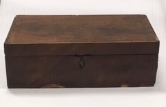 Reiseskrivebord i tre, mahognifinèr, skriveplate med grønn filt. Inneholder 3 blekkhus, 3 penner med pennespiss, 1 mekanisk blyant, 1 frimerke. Ang. tilhørt Oscar Borg.