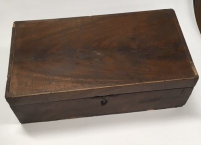 Reiseskrivebord i tre, mahognifinèr, skriveplate med grønn filt. Inneholder 3 blekkhus, 3 penner med pennespiss, 1 mekanisk blyant, 1 frimerke. Ang. tilhørt Oscar Borg.