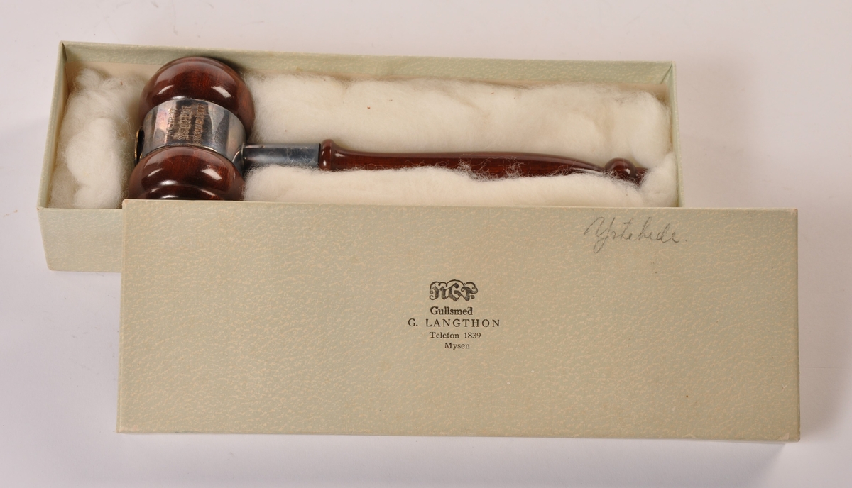 Styreklubbe i dreid, lakkert tre, beslått med metall og et emaljert merke. I pappeske (m/bomull) merket Gullsmed G. Langthon, Mysen.
