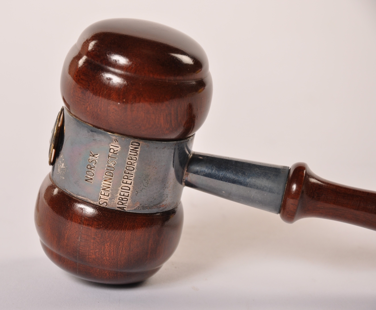 Styreklubbe i dreid, lakkert tre, beslått med metall og et emaljert merke. I pappeske (m/bomull) merket Gullsmed G. Langthon, Mysen.