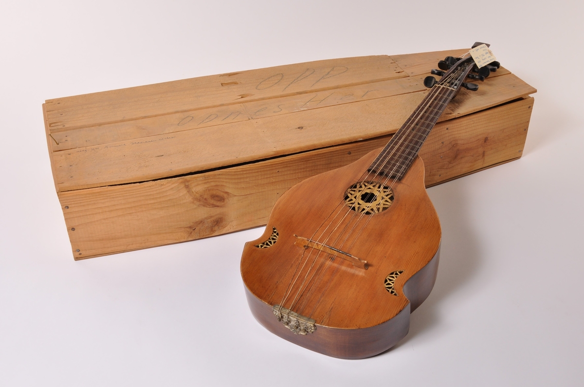 Cister i tre med sekundær tilpasset kasse . 10 strenger. Pæreformet sarg med tre gjennombrudte partier på lokket. Gullmalt dekor i gjennombrudte partier.  Gripebrett, hals og stemmeskruer i tre.. Hals avsluttet i en plate.  Papir etikket inne i sargen: Amund Hansen, Friderichs. hald Ano 1797.