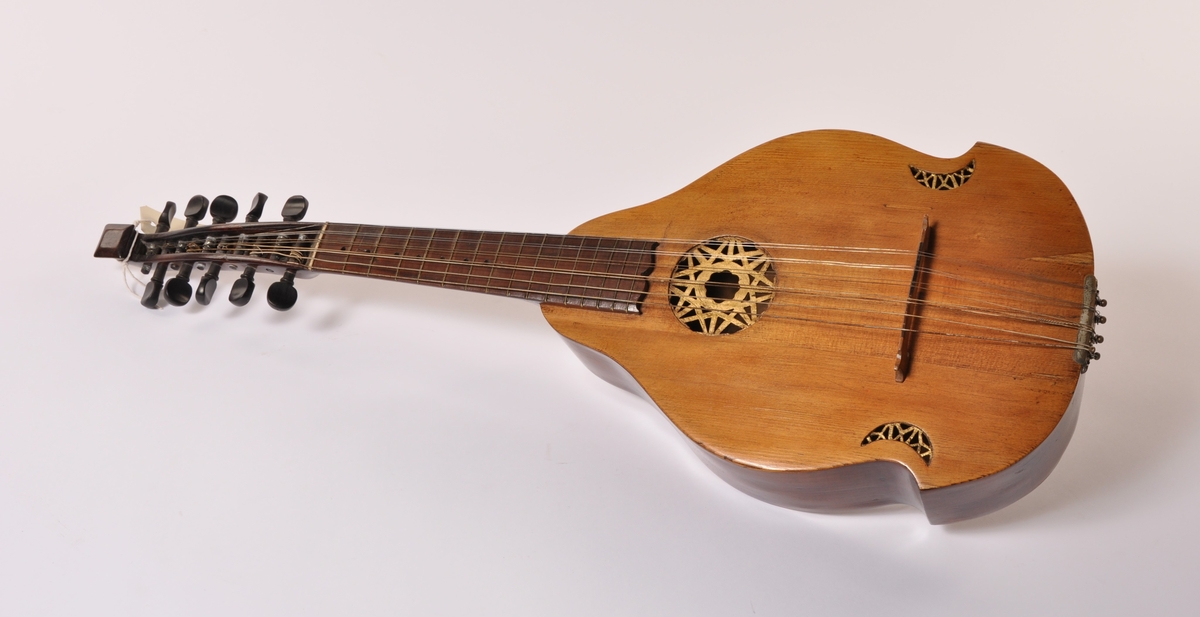 Cister i tre med sekundær tilpasset kasse . 10 strenger. Pæreformet sarg med tre gjennombrudte partier på lokket. Gullmalt dekor i gjennombrudte partier.  Gripebrett, hals og stemmeskruer i tre.. Hals avsluttet i en plate.  Papir etikket inne i sargen: Amund Hansen, Friderichs. hald Ano 1797.