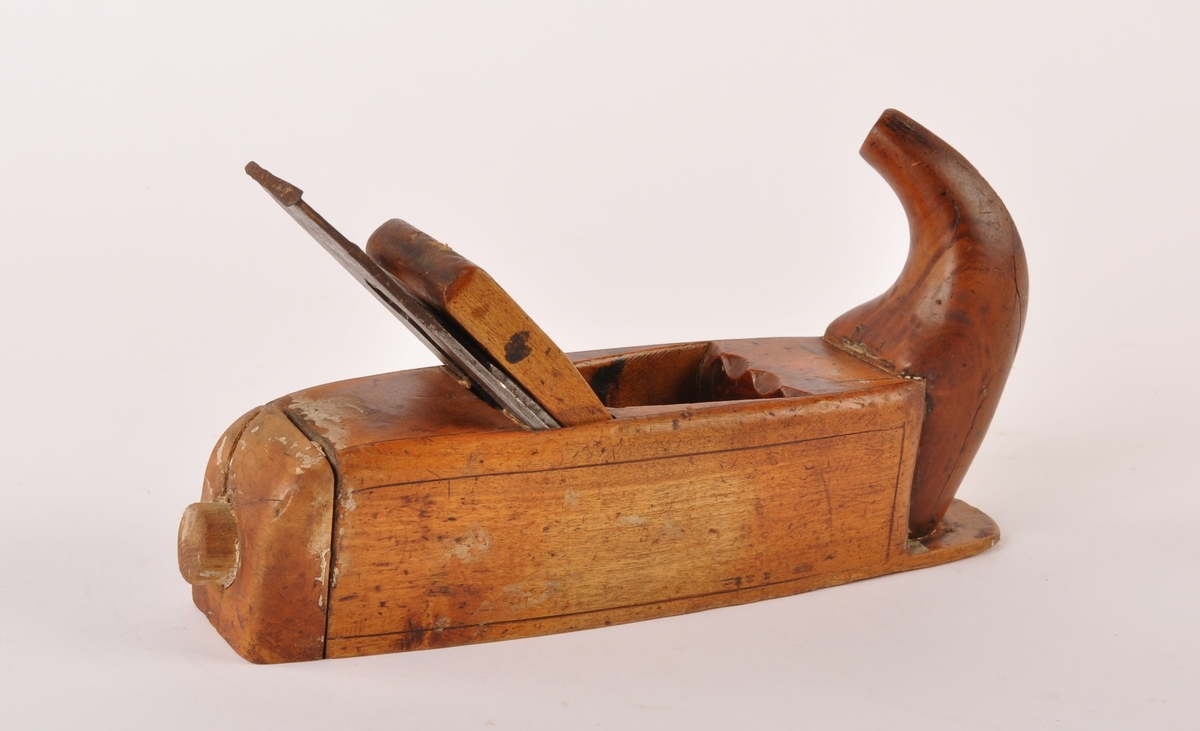 Høvel i tre.med tann av metall. Ergonimisk håndtak, rett såle.