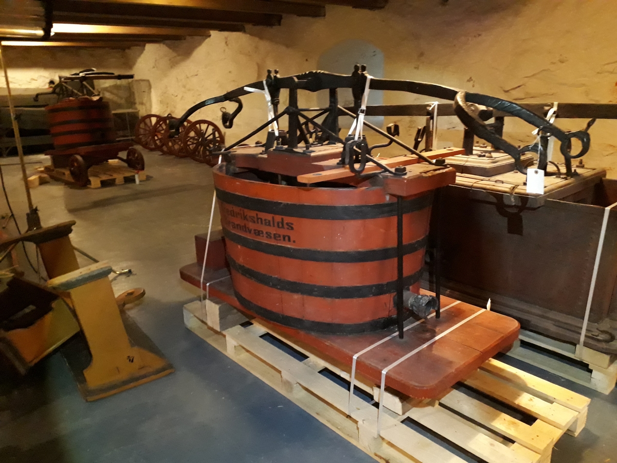 Pumpevogn i rødmalt tre med 4 jernbeslåtte hjul med drag til hest. På vogn montert tønne av rødmalt tre med pumpesystem for håndpumping. Ved pumpe flere bøyler for oppbevaring av brannutstyr. Tønne er belått med kobber på innside. Påmontert verktøykasse bak.