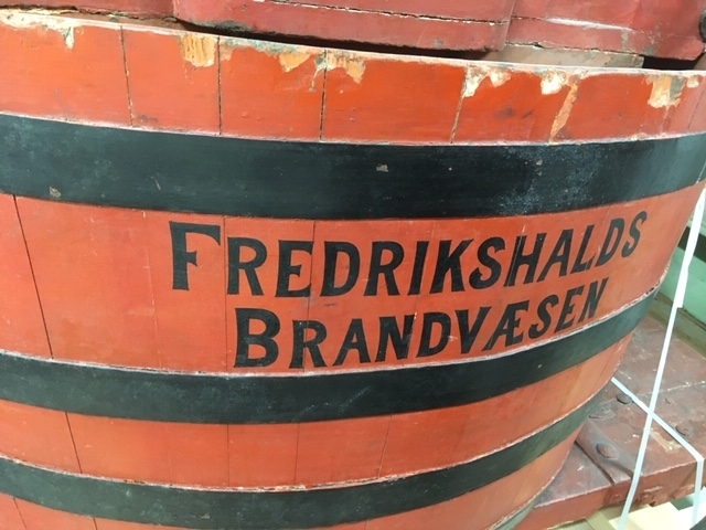 Pumpevogn i rødmalt tre med 4 jernbeslåtte hjul med drag til hest. På vogn montert tønne av rødmalt tre med pumpesystem for håndpumping. Ved pumpe flere bøyler for oppbevaring av brannutstyr. Tønne er belått med kobber på innside. Trekasse rundt pumpehus i tønna.