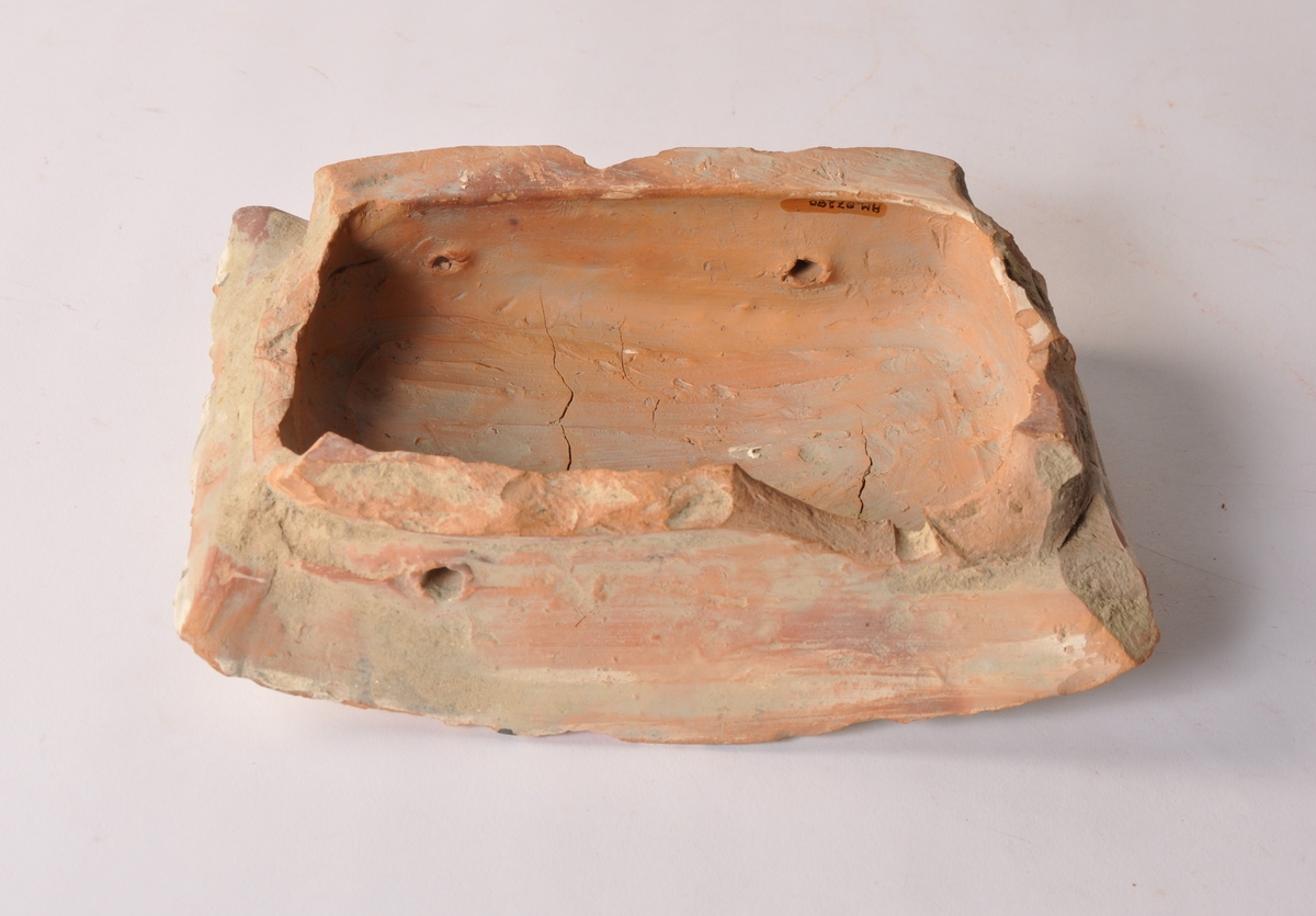 Kakelovn i deler fordelt i 16 trekasser av forskjellig størrelse, i tillegg 4 deler i pappeske. Deler av støpt kakel, glassert i gul og grønn med motiv av svaner.