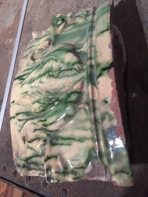 Kakelovn i deler fordelt i 16 trekasser av forskjellig størrelse, i tillegg 4 deler i pappeske. Deler av støpt kakel, glassert i gul og grønn med motiv av svaner.