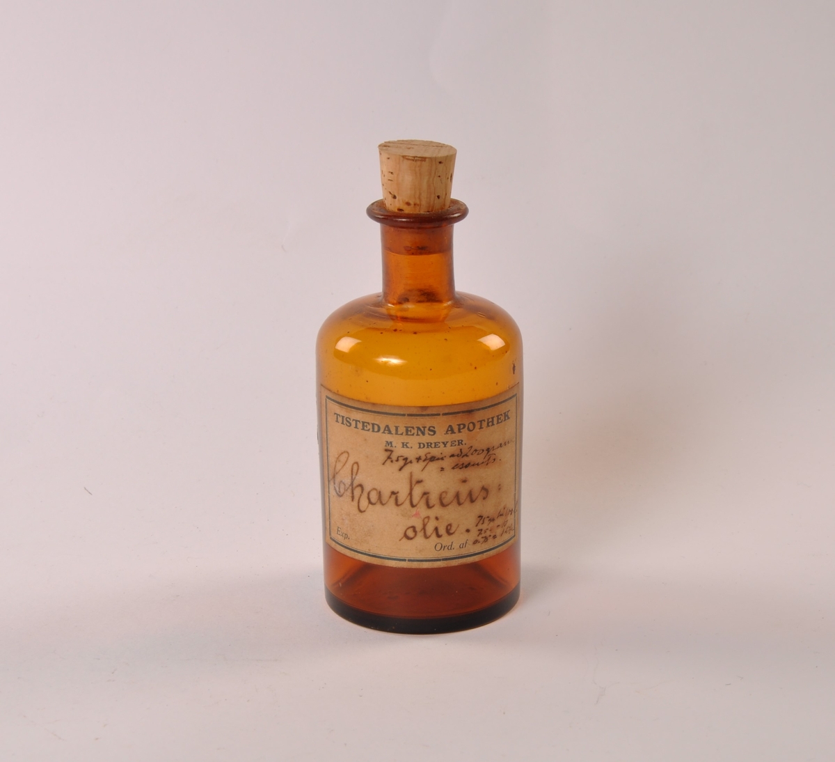 Flaske i brunt glass med rund hovedform, smalere hals. Kork