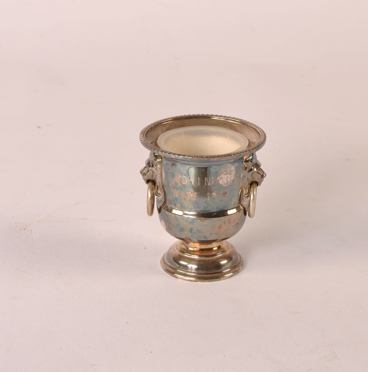 Hundepremie i form av liten urne eller blomstervase i hvitt metall. Hankeringer. Plastinnsats.